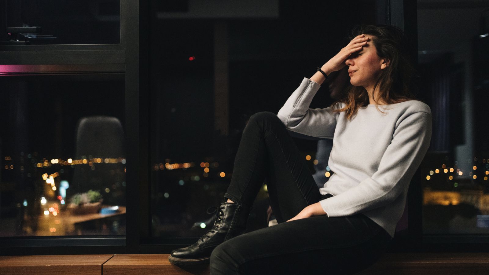 A girl sitting on the window reliving her traumatic stresses