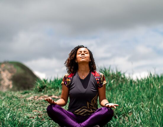 Young woman meditating outdoors in the fields