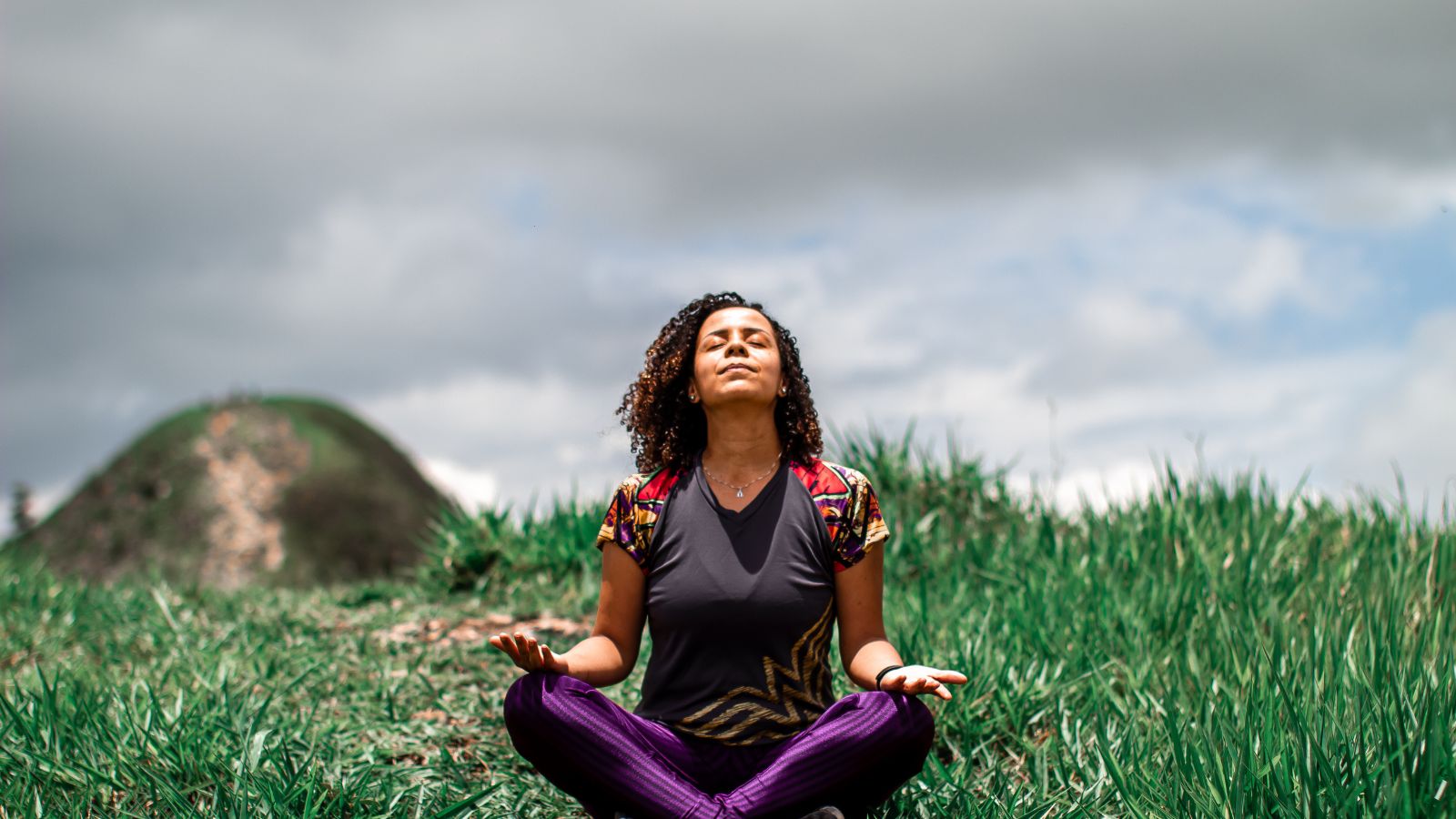 Young woman meditating outdoors in the fields