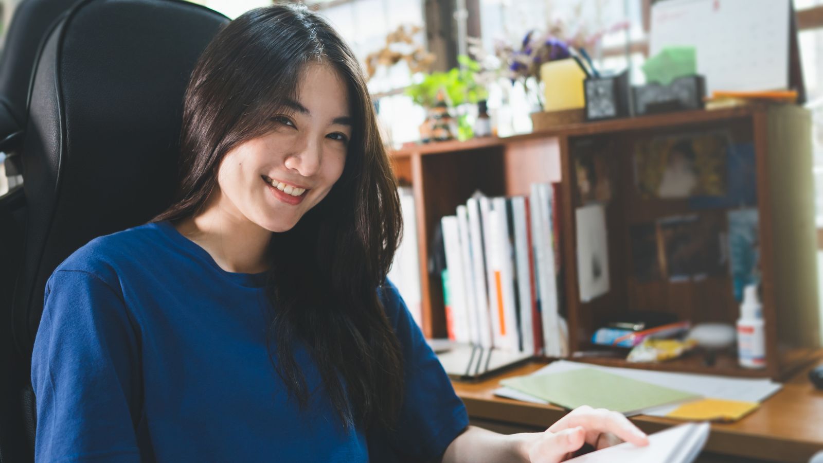 Happy woman reading a book in her home