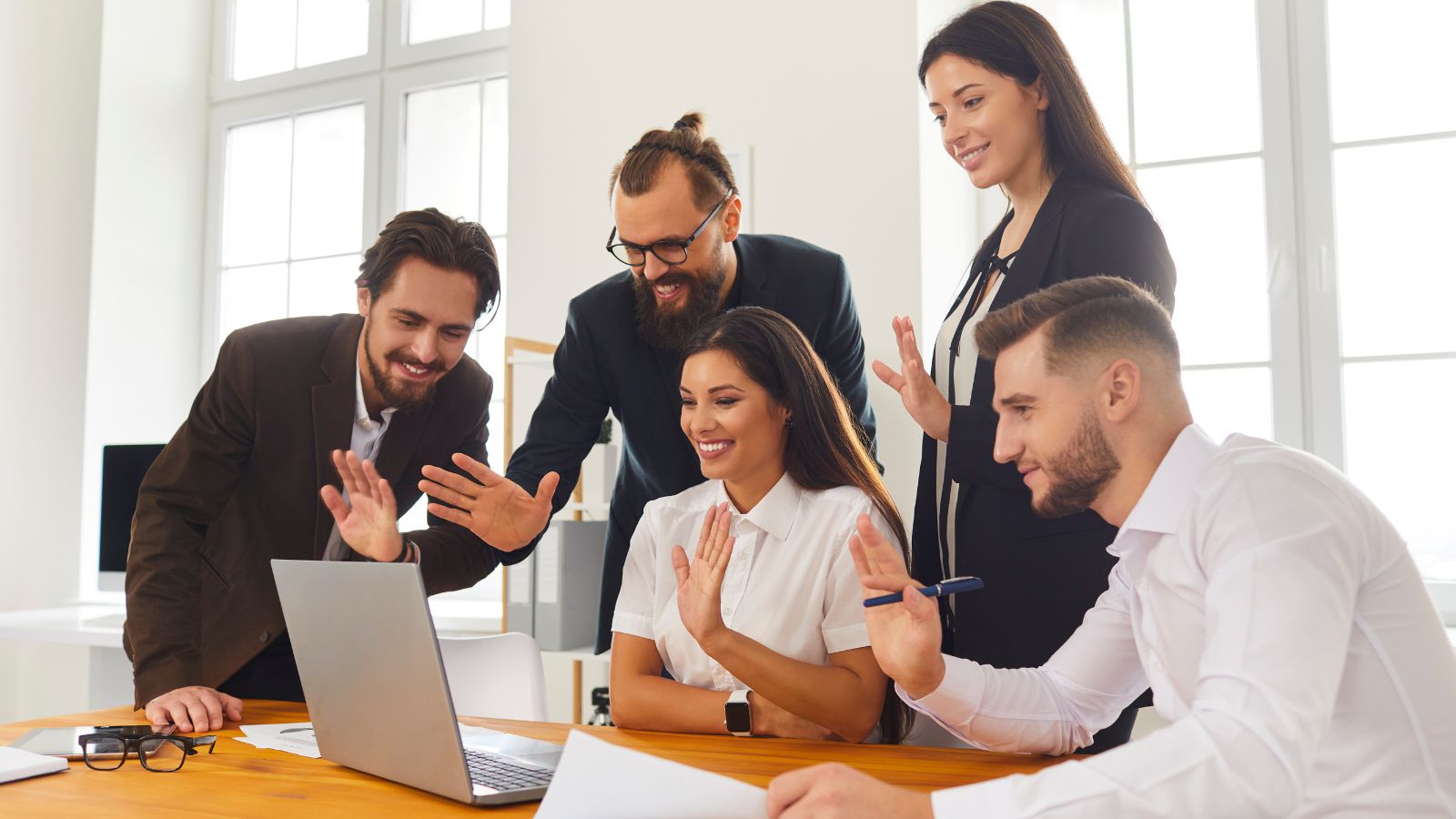 Happy company employees excitedly talking with their boss on a video call