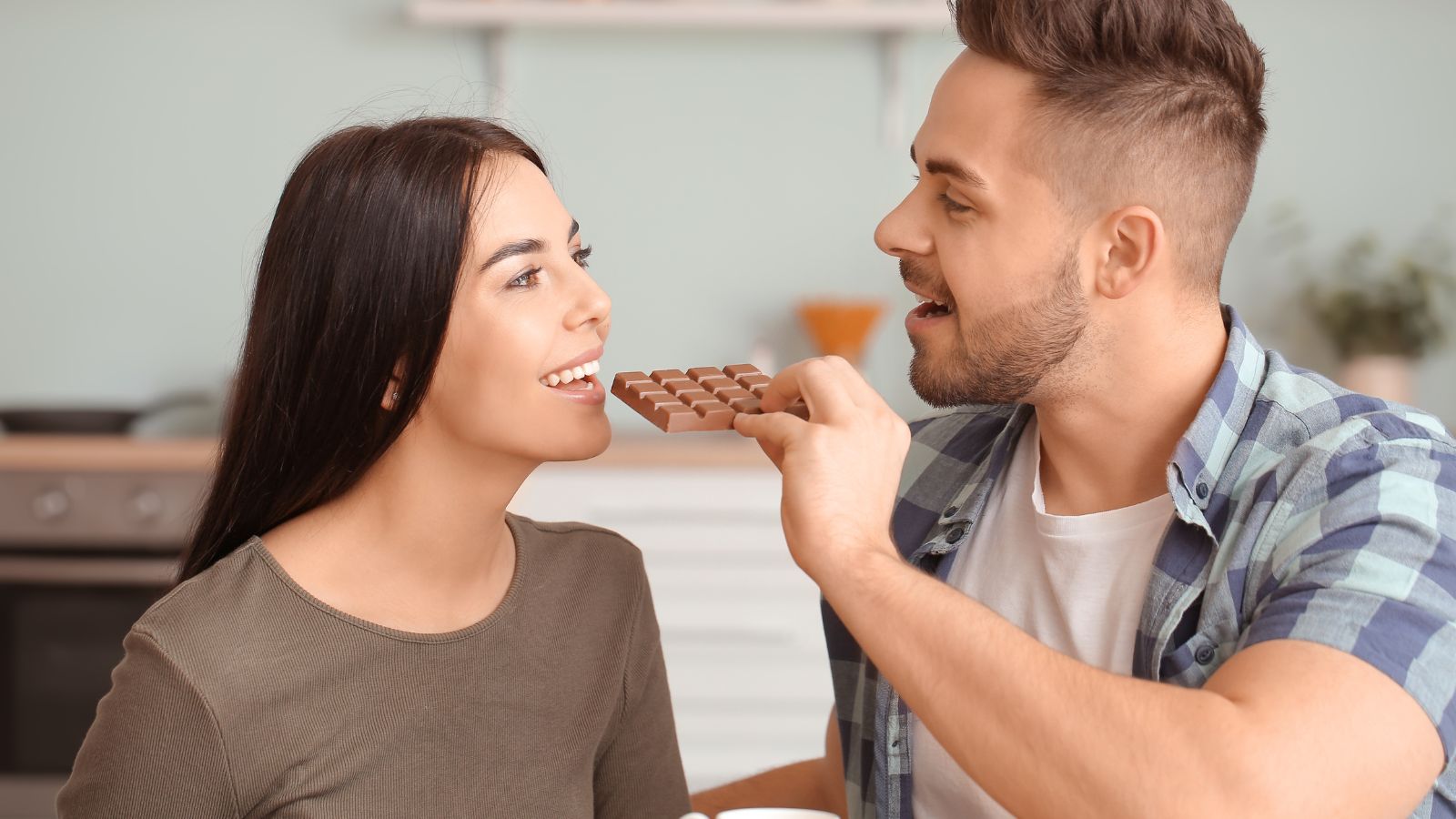 A man feeding his wife chocolate bars