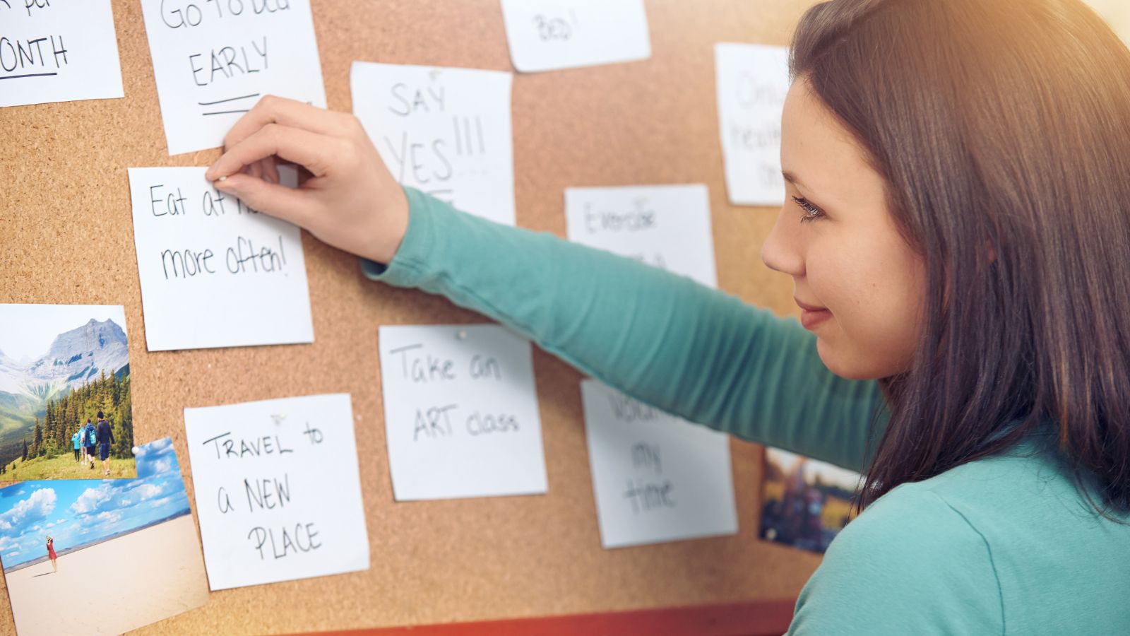 A woman pinning her goals on her vision board