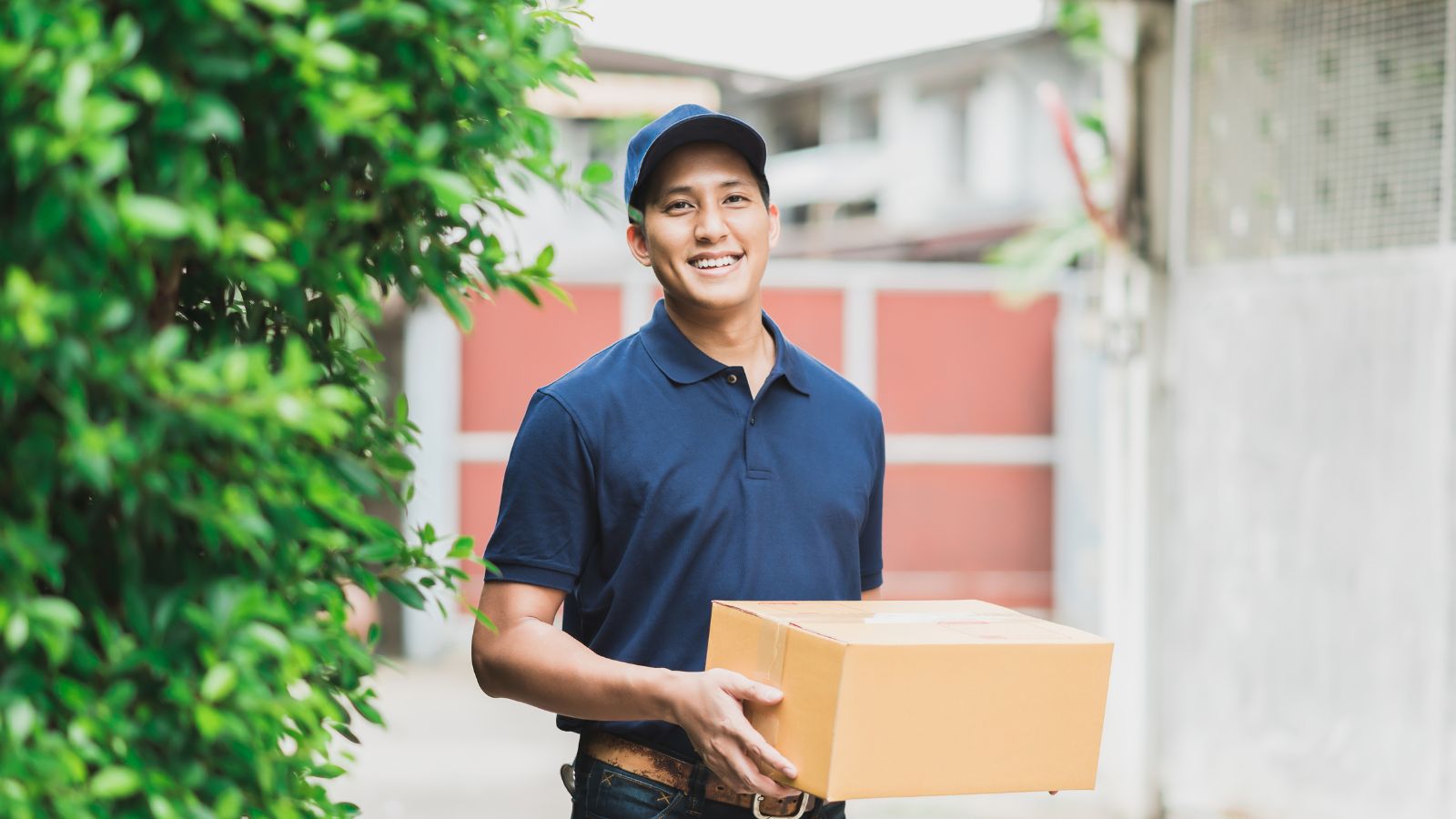 Young delivery man holding a package for delivery