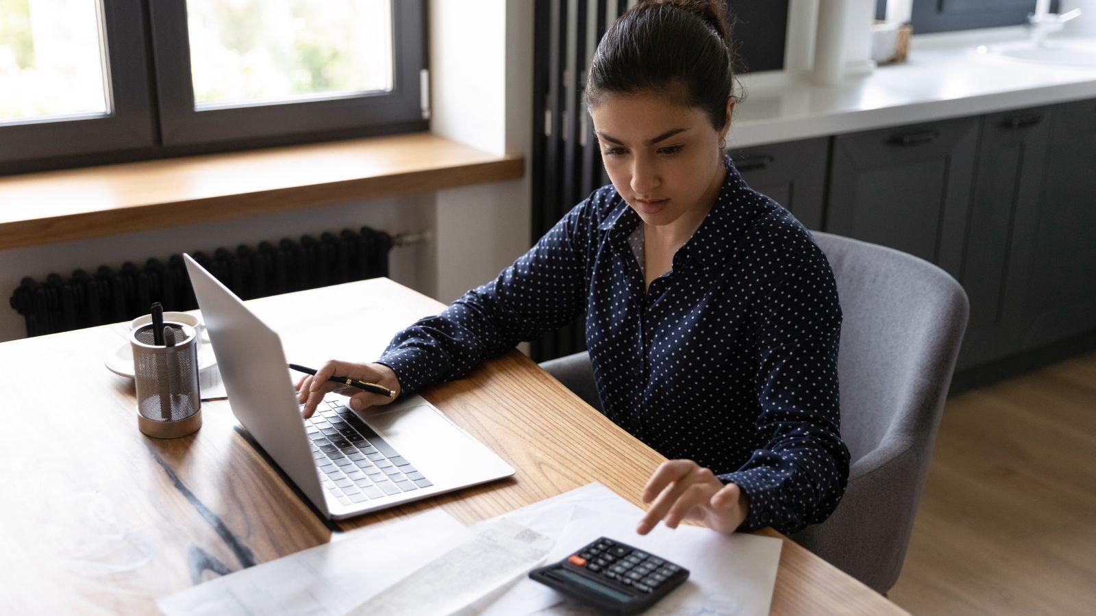 financial reports - lady at desk with computer and calculator