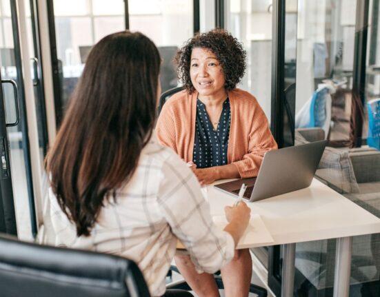 two ladies at desk talking hiring