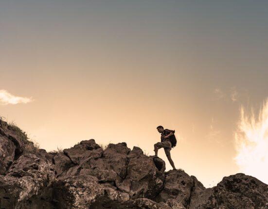 man climbing on rocks